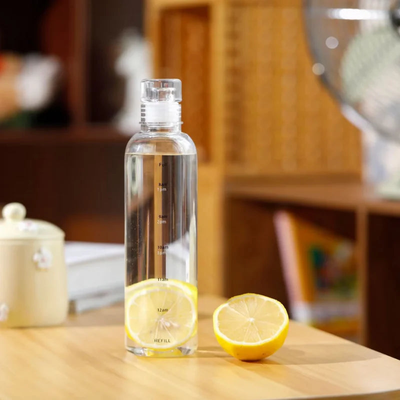 Clear water bottle with lemon slices on a wooden table