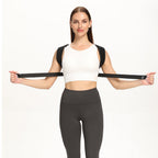Woman in a white top stretching the posture corrector belt strap behind her back to show its elasticity